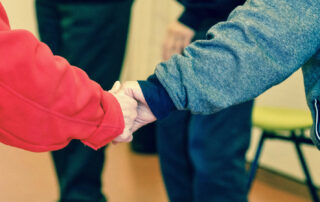 Image of two elderly people holding hands in hospital